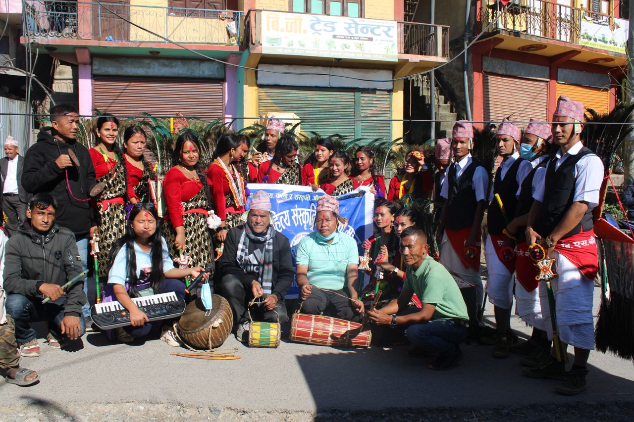 A vibrant group in traditional attire celebrating a cultural festival in Musikot Khalanga, Nepal.